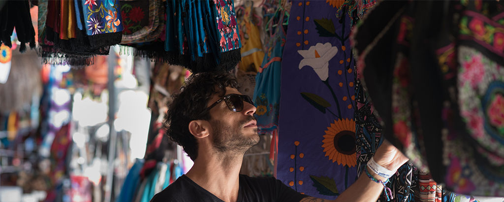 young man watching crafts handcrafted fabrics in cancun