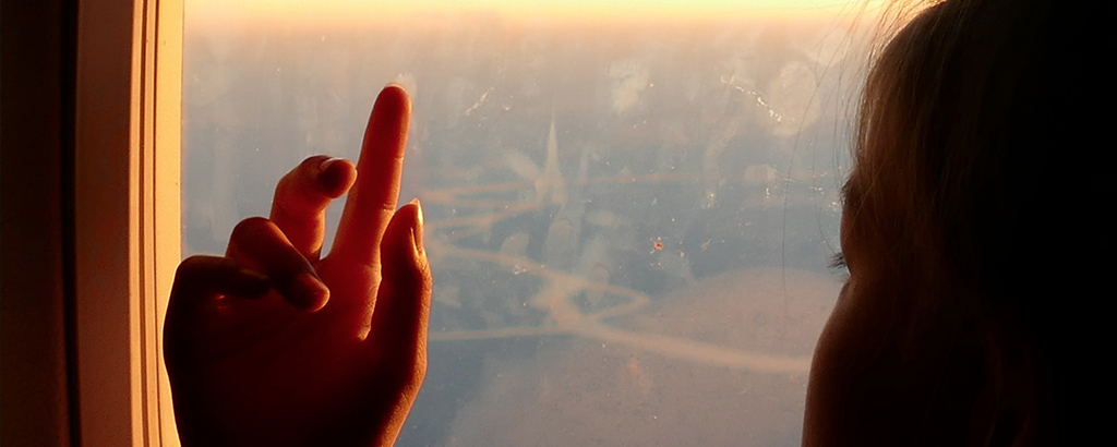 kid looking trough the airplane window