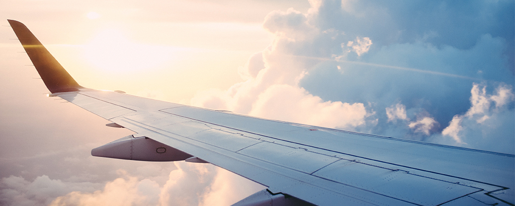 wing of an airplane with clouds in the background