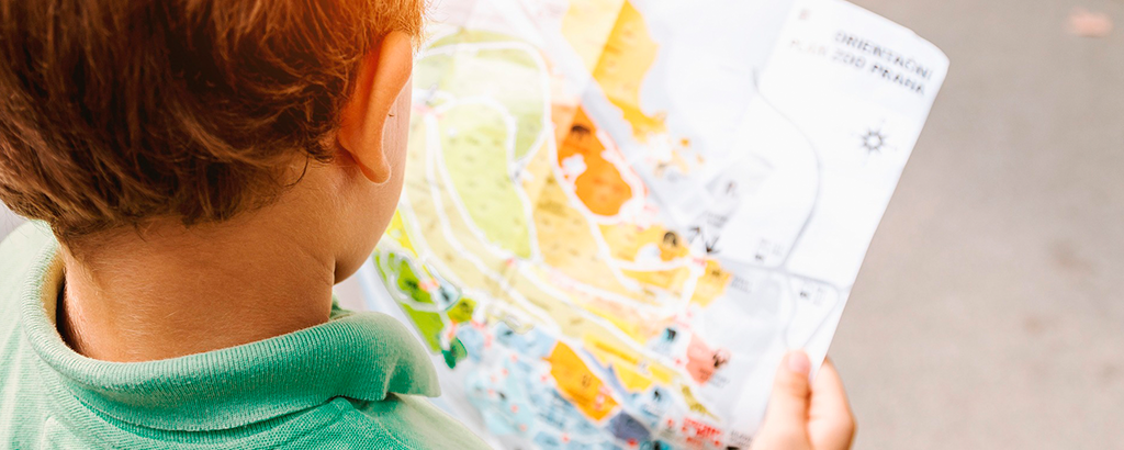 niño de espalda a la camara viendo un mapa de cancun